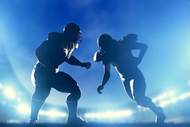 American football players in a game at night.