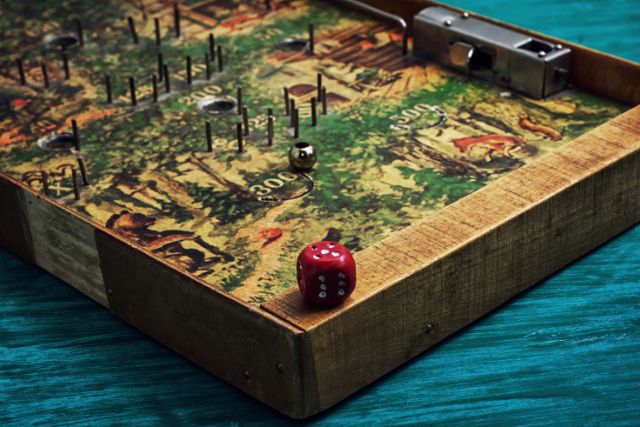 An ancient looking board game that uses a dice.