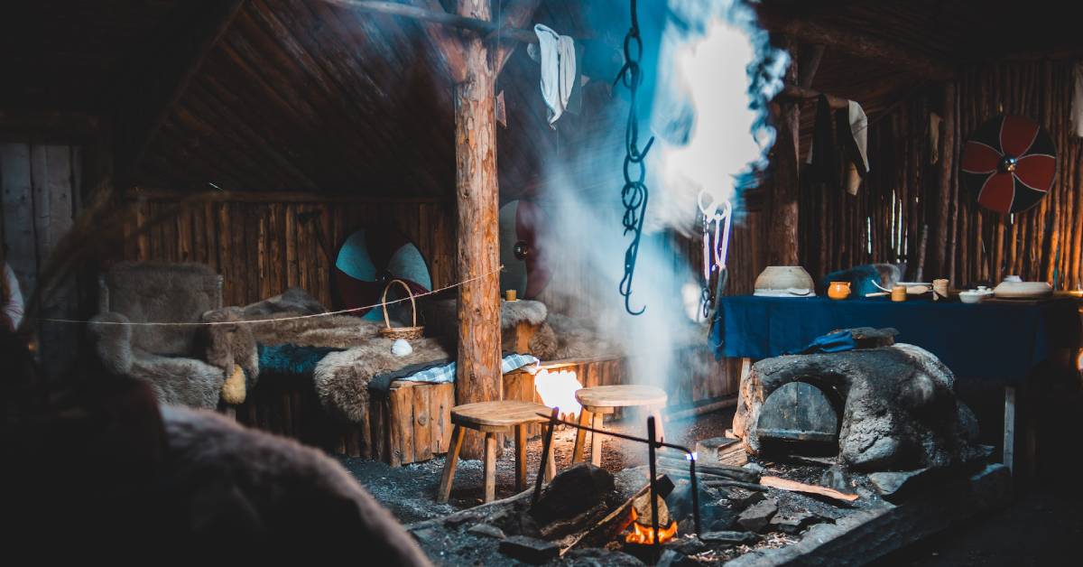 Interior of traditional old Viking shed with burning fireplace.