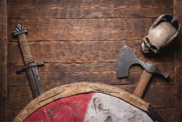 Old vikings battle weapons in a wooden background.