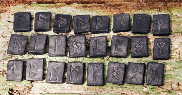 Old rune alphabets engraved in black stones.