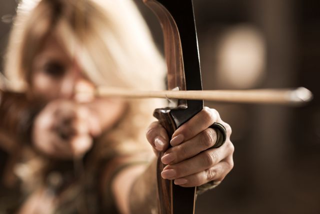 Female viking warrior practicing archery.