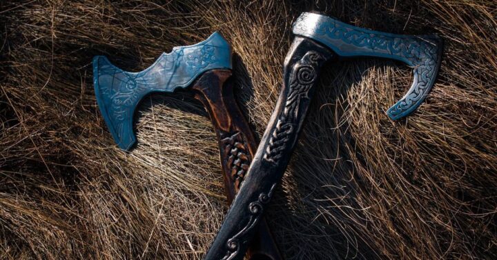 Two viking axes lying on a pile of hay.