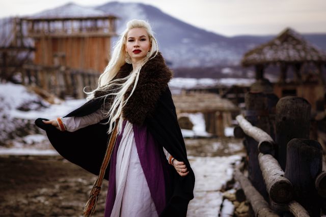 Blond viking woman in black cloak.