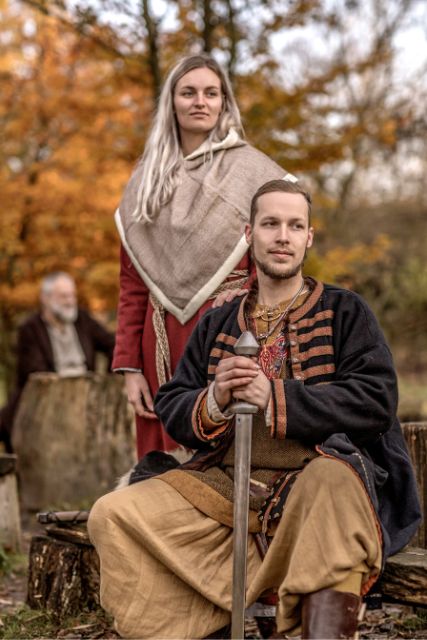 A viking couple in a village settlement hall.