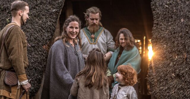 A reenactment of a viking family in a settlement setting.