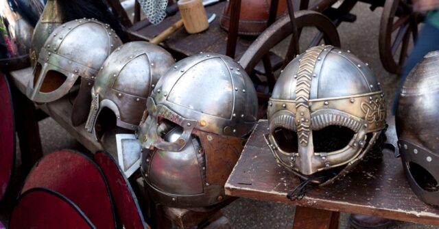 Various viking helmets displayed on a stand.