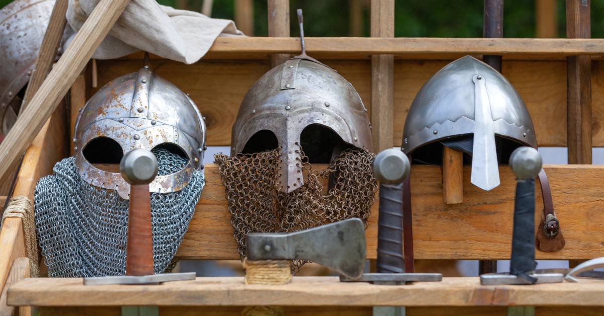 Different kind of viking helmet displayed on a wooden table.