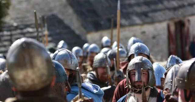 A group of vikings holding a spears.