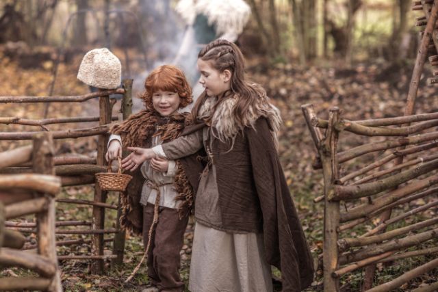 Viking kids on a settlement holding a small basket.