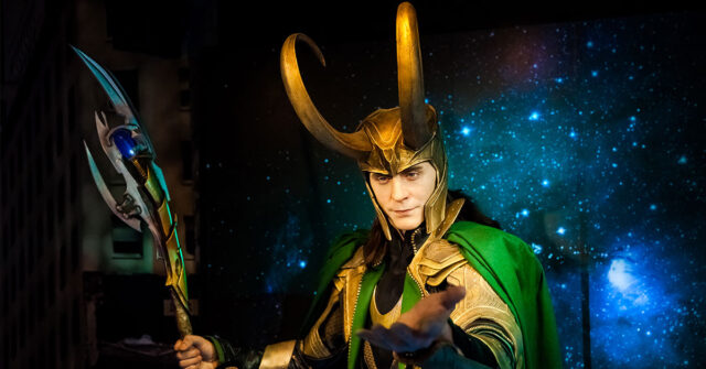Representation of Loki with horned helmet holding a spear like weapon with large blade.
