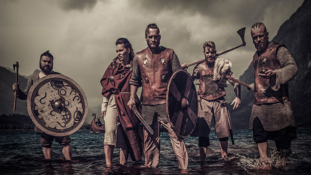 Group of Vikings standing in the water with weapons