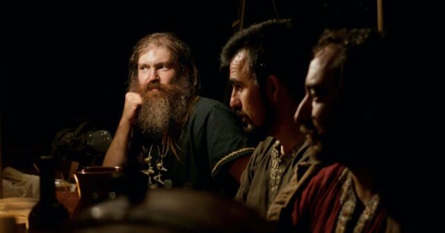 Three vikings having serious conversation over a meal.