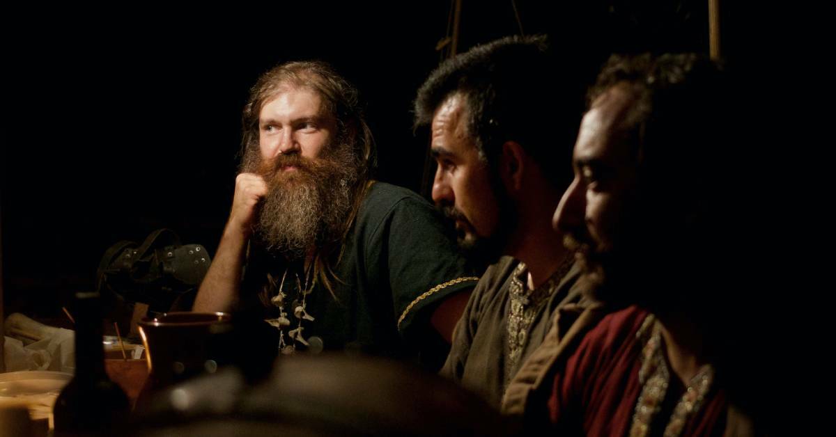 Three vikings having serious conversation over a meal.