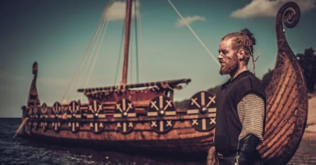 Viking standing in front of a Long Boat