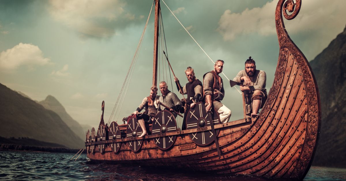 Long Viking ship travelling on water with Vikings on board
